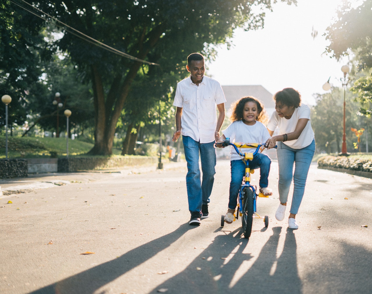 Mother is helping riding bicycle to her daughter